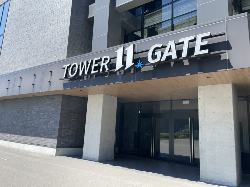 Fヴィレッジ TOWER 11 GATE の入口。青い星の意匠と木のルーバー天井