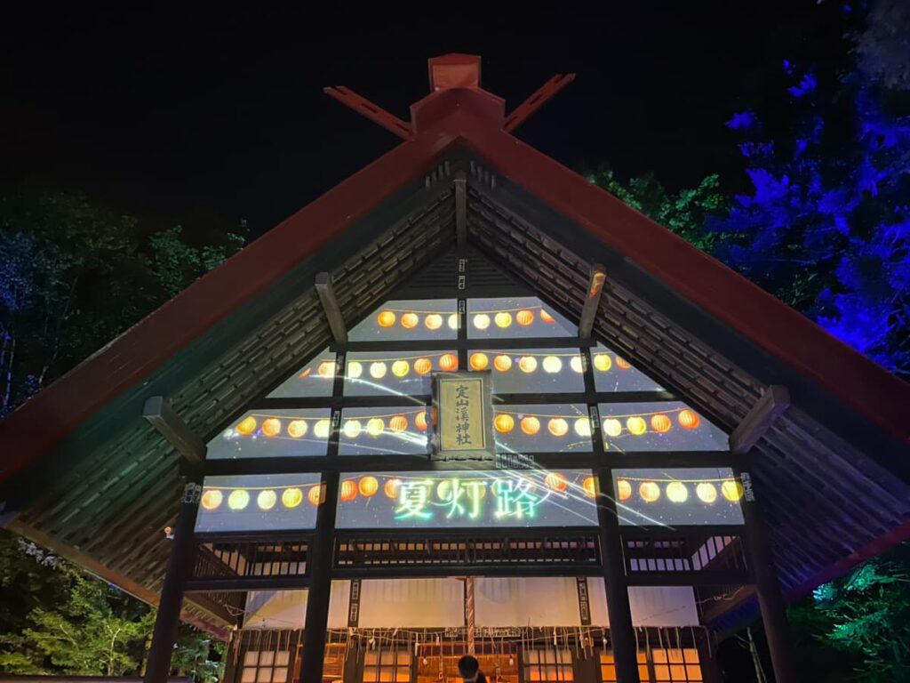 「夏灯路」の文字が映し出された夜の定山渓神社