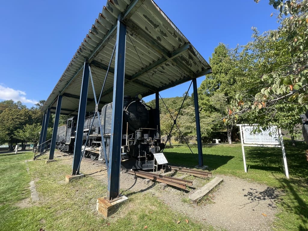 屋根付きの展示場所に保存された栗山公園の蒸気機関車全景