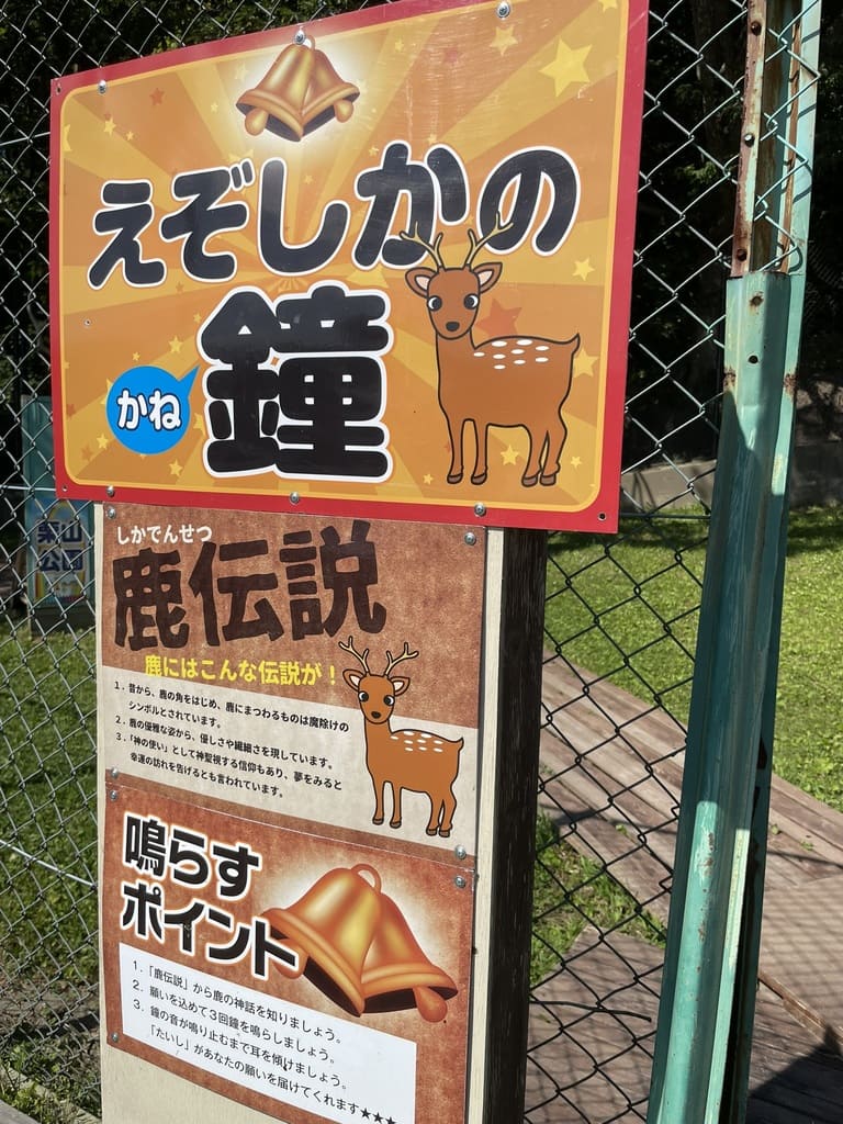 鹿伝説とえぞしかの鐘の鳴らし方を説明するなかよし動物園の案内板