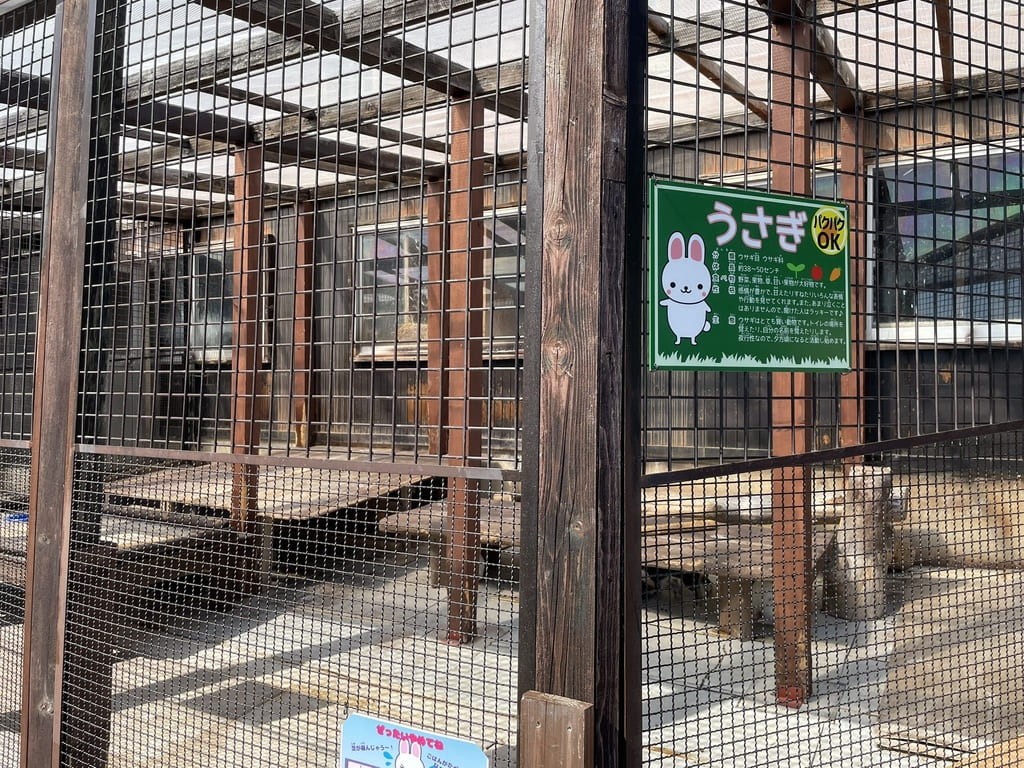 緑色のウサギ解説板が掲げられたなかよし動物園の飼育舎