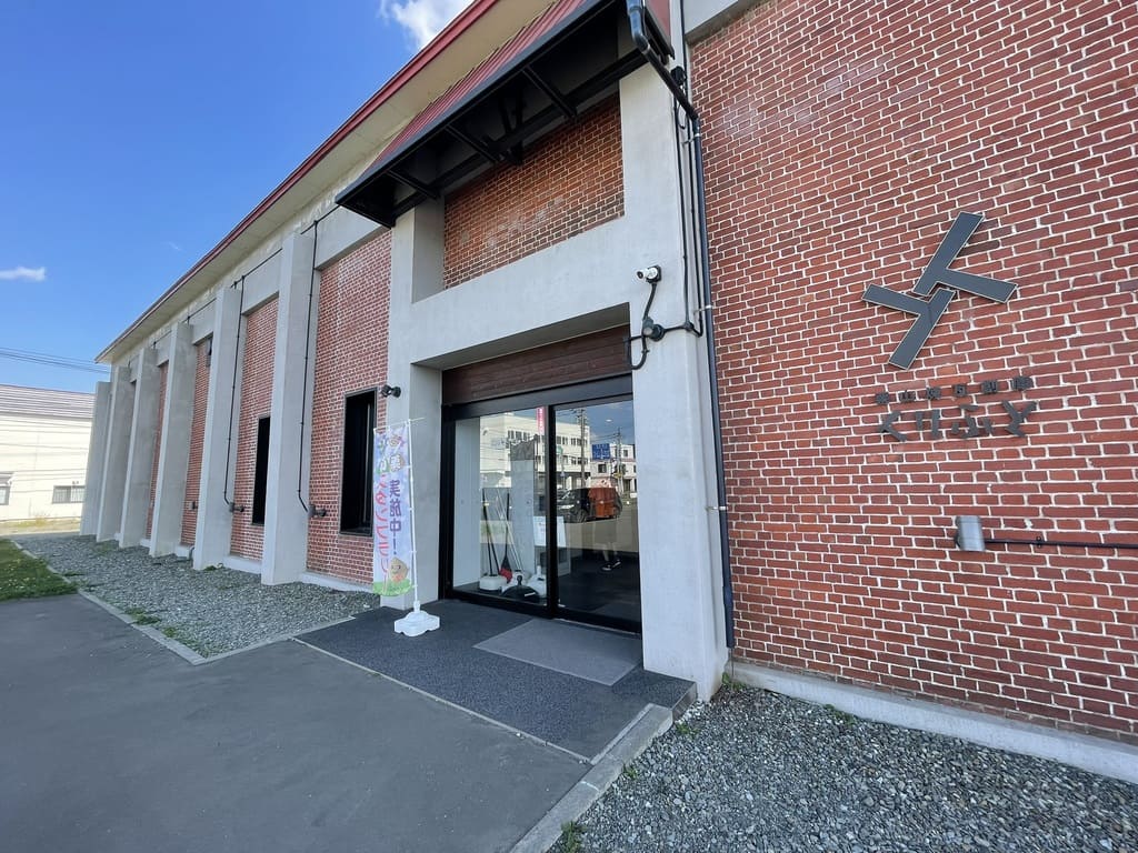 煉瓦壁のロゴとガラス扉がある栗山煉瓦創庫くりふとの正面入口