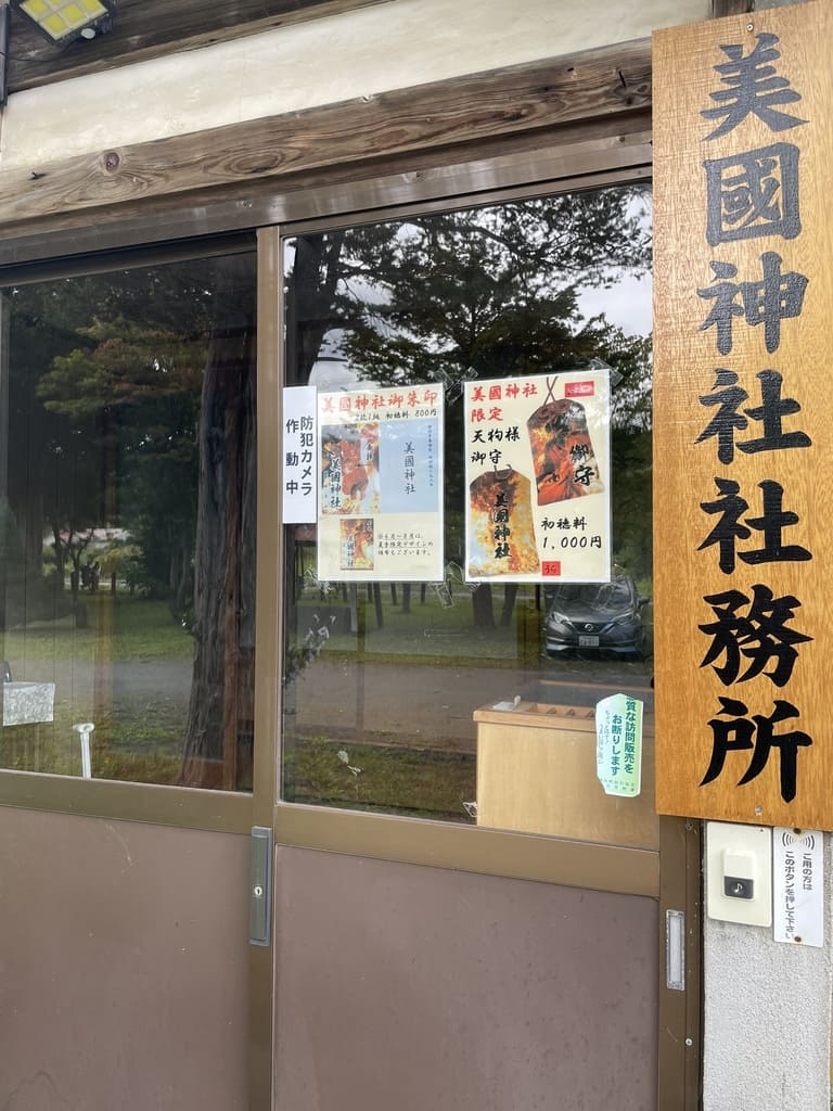 美国神社社務所入口に掲示された御朱印と天狗のお守り案内
