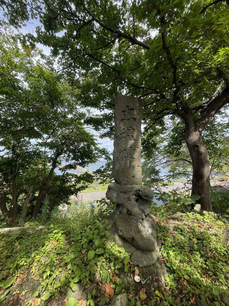 神威神社境内の木々の中に残る石碑