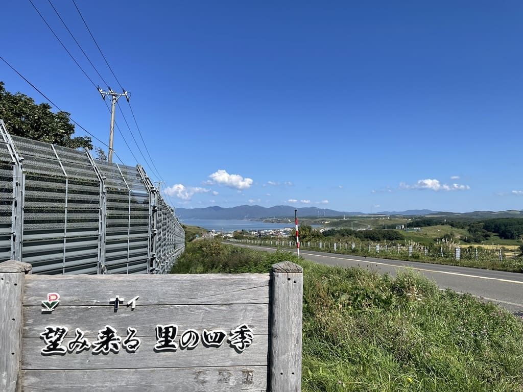 「望み来る 里の四季」の看板と石狩市望来の日本海を望む景色