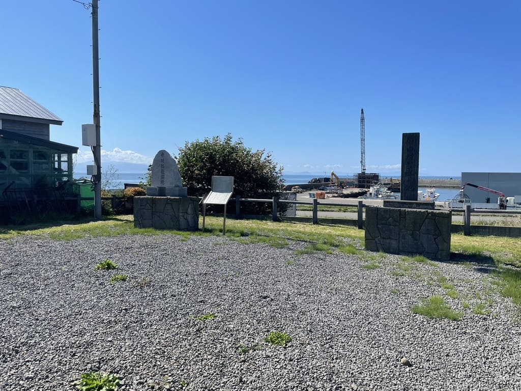 古潭漁港を背景に建つ弁財船投錨地碑と厚田村発祥之地碑