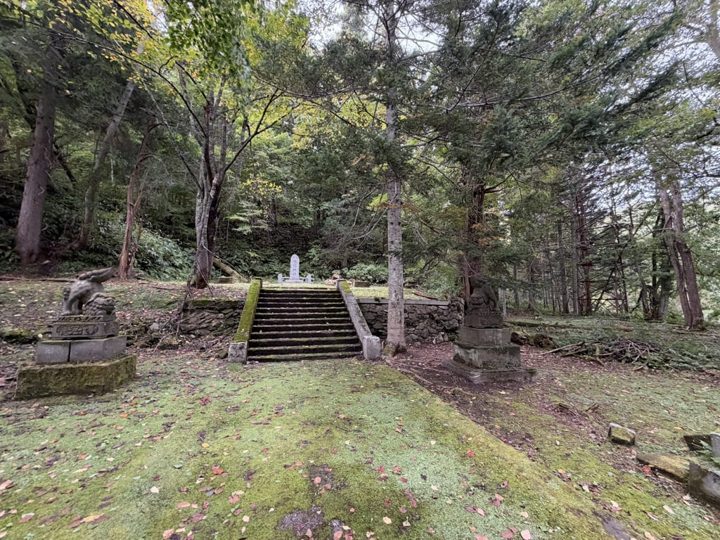 幌内神社本殿跡に残る狛犬と石段、森林に囲まれた境内の様子