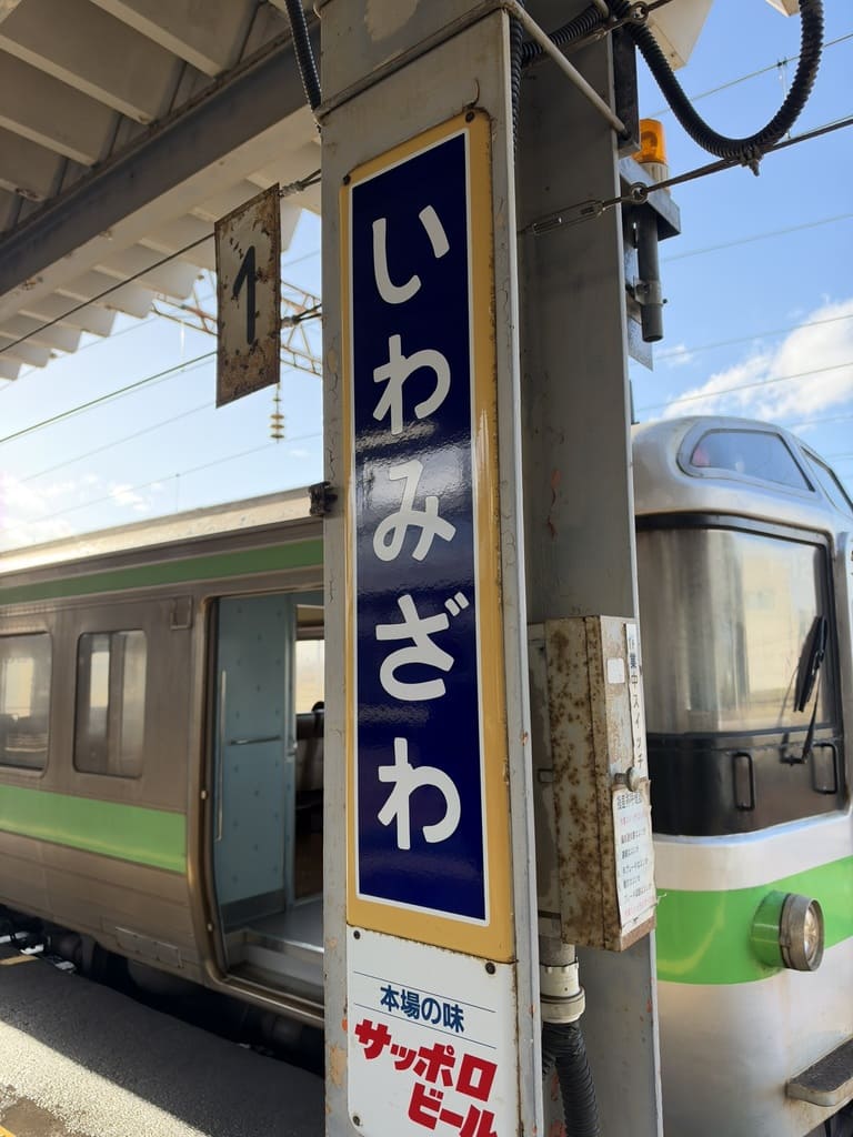 JR岩見沢駅ホームの駅名標と列車