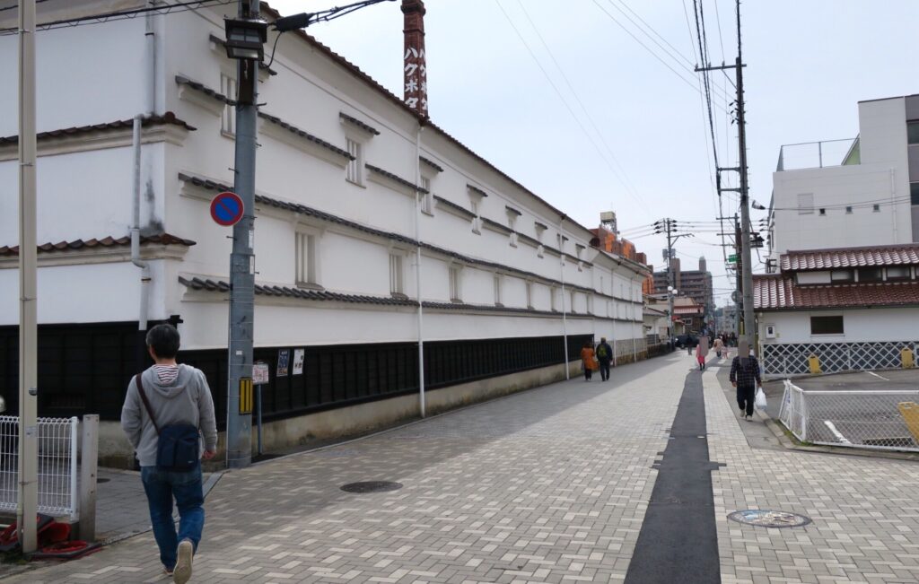 白壁の酒蔵と赤レンガの煙突が立ち並ぶ風情ある街並み