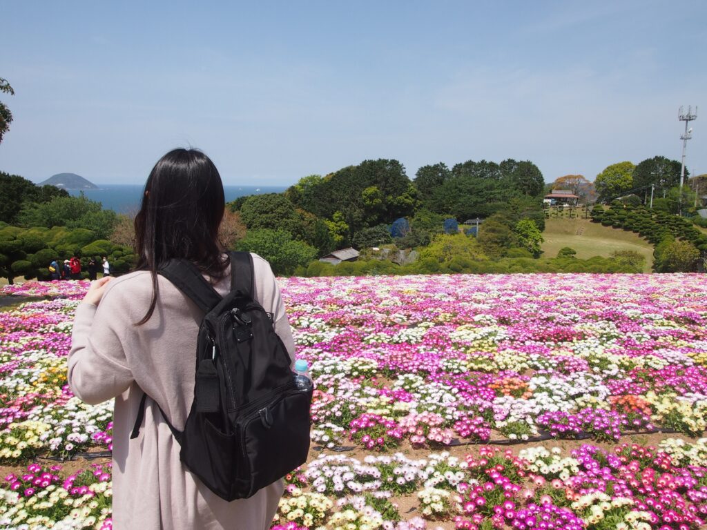 福岡県福岡市西区の能古島の花を見る女性